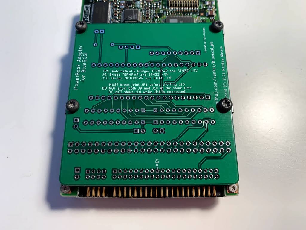 Picture of bare bluescsi_pb board attached to bottom of 2.5in SCSI drive to show size differences