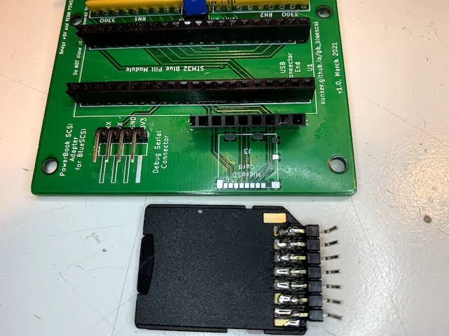 Picture of MicroSD connector pad and SD-to-MicroSD adapter with header pins soldered to it